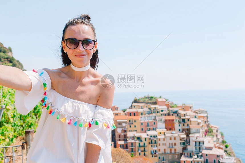 蜜月意大利Liguria夏季假期背景与意大利河沿岸背景的老村庄年轻女子背面观景Yengwomeninoldvillage年轻的女图片