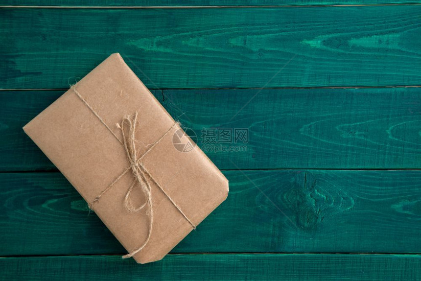 浅褐色的盒子以深绿木背景的生态友好纸包装在从上到下视图中有质感的图片