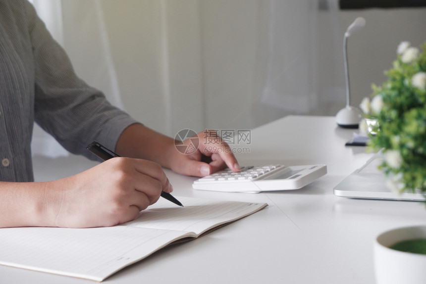 便携的互联网利用便携式计算机设备通过手提笔记本电脑年轻女经理对在办公室工作的专业商妇女形象进行裁剪单位女沟通图片