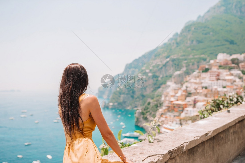 游客美丽地标意大利阿马尔菲海岸波西塔诺滩的年轻女子意大利暑假阿马尔菲海岸波西塔诺村背景的年轻女子图片
