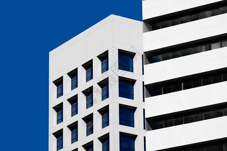 抽象的蓝色天空上现代建筑外观的精细简微风格架构背景表情窗户正面图片