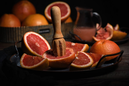 新鲜葡萄汁的切片为在黑暗背景的盘子上制造新鲜果汁而准备的鸡尾酒饮食图片