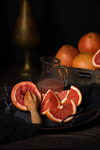 生态低卡路里新鲜葡萄汁的切片为在黑暗背景的盘子上制造新鲜果汁而准备的图片