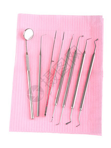 在职的镜子白底孤立粉红色小斑点上的牙科手术器械磨光机背景图片