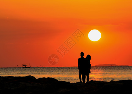 常设手一对情侣的休眠站在海边观看日落滩图片