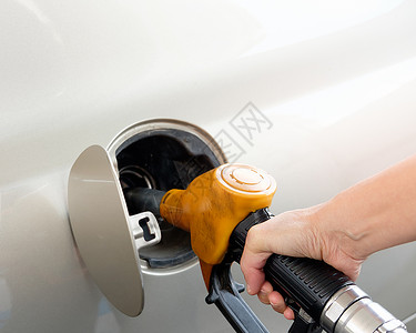 填金子色汽车正在加油站手持煤气泵中燃料喷嘴的油罐笔芯图片