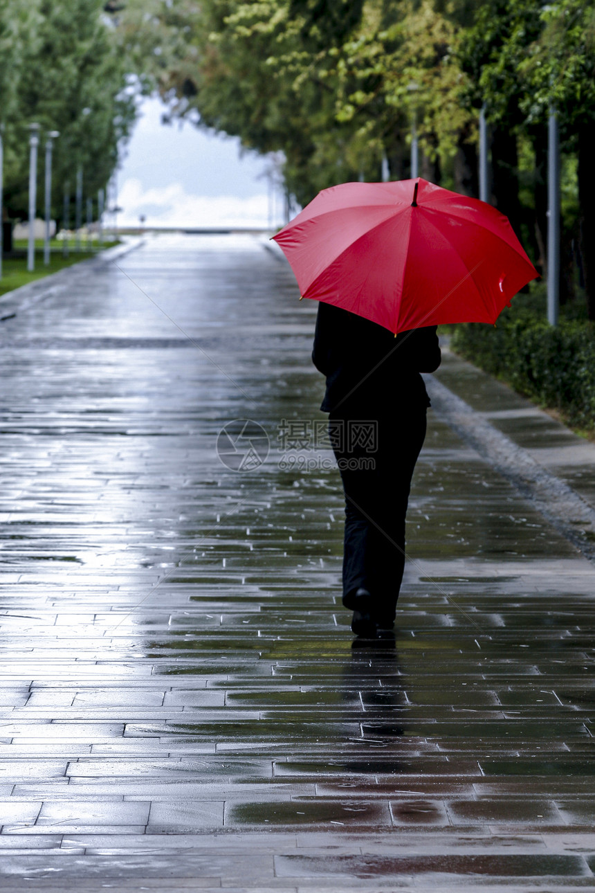 春天户外运输在土耳其湿路上行走的红色雨伞妇女图片