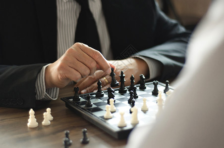 在任战略和竞争概念中玩棋子的商人象游戏斗争白色的赢图片
