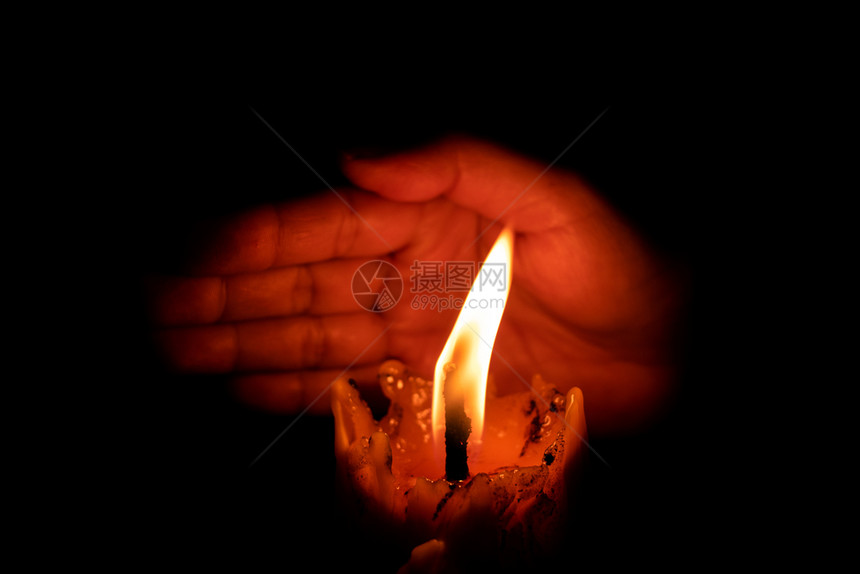 空气火手保护蜡烛的灯光防止黑底暗中的风橙图片