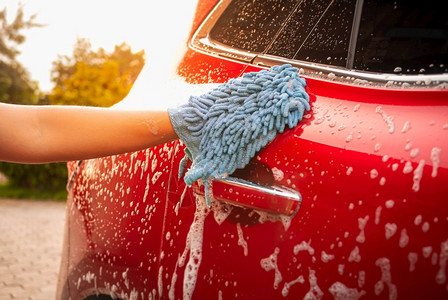 玻璃外部的手靠近是用套洗车气泡肥皂在户外图片
