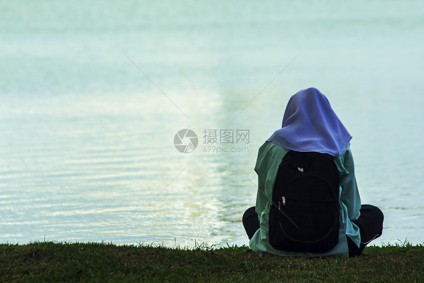 坐在湖边的妇女年轻绿色草图片
