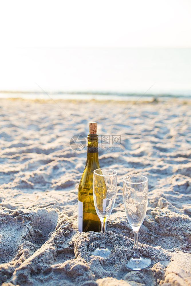 岛幸福酒和杯站在沙滩上的子酒和杯站在海滩上的沙子里旅行图片