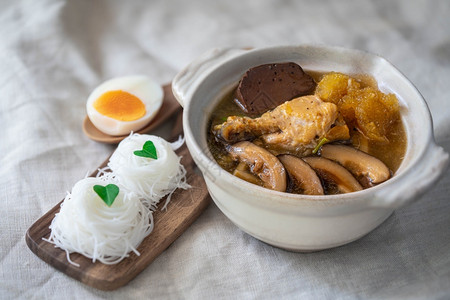 碗蔬菜用鸡肉竹子和芝麻蘑菇煮红汁汤中的青鱼丸蛋黄图片