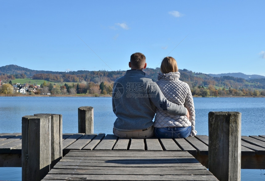 途径落下一对在瑞士湖木制码头的夫妇安静图片