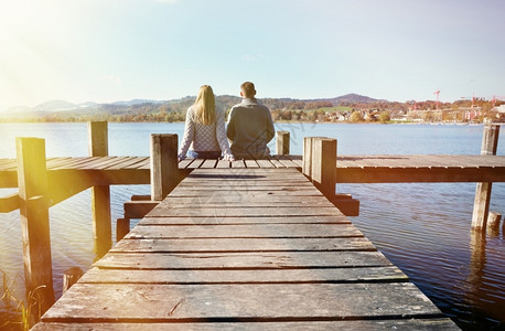 在湖边木制码头的一对夫妇桩会议独自的图片