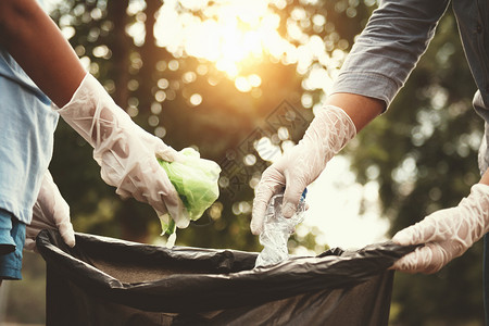草采摘妇女用手捡垃圾塑料在公园打扫斌图片