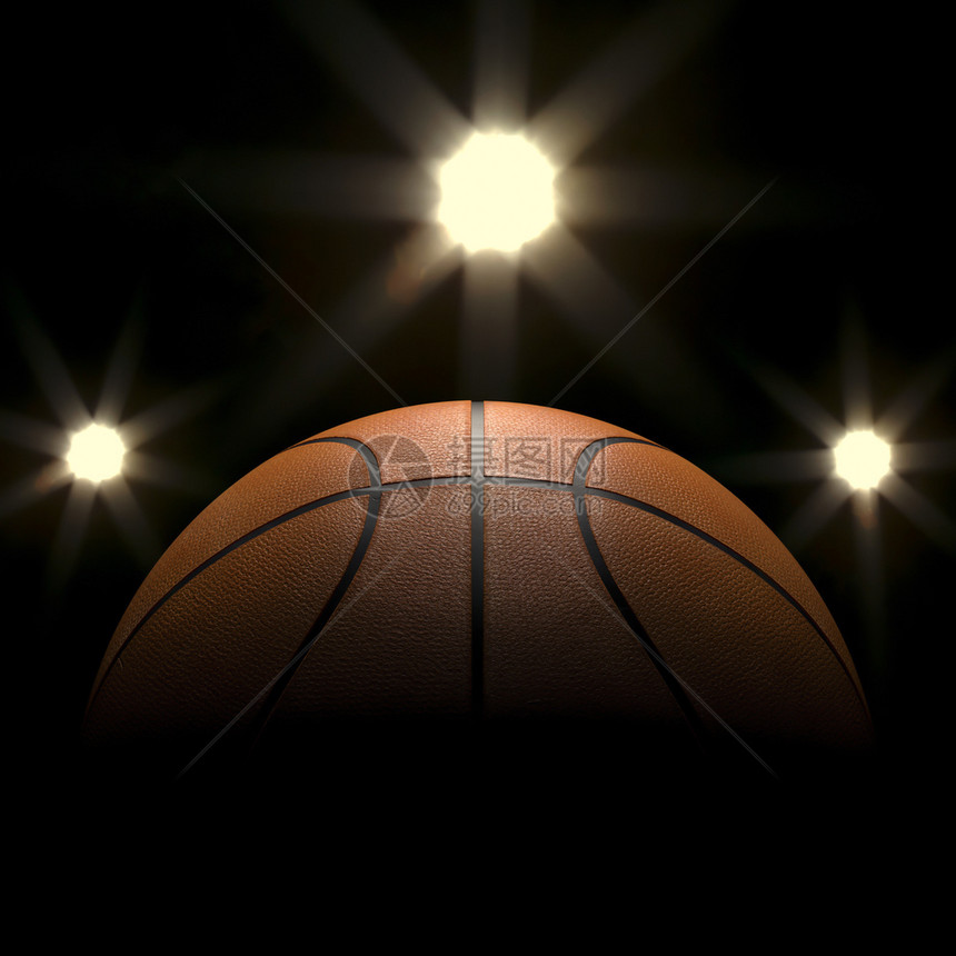 分数玩篮球在黑色背景与聚光灯的Bokoh橡胶图片