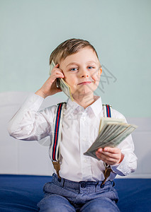银行金融可爱的男婴玩很多钱比如打电话美国一百元现金国一百元现金用商业图片