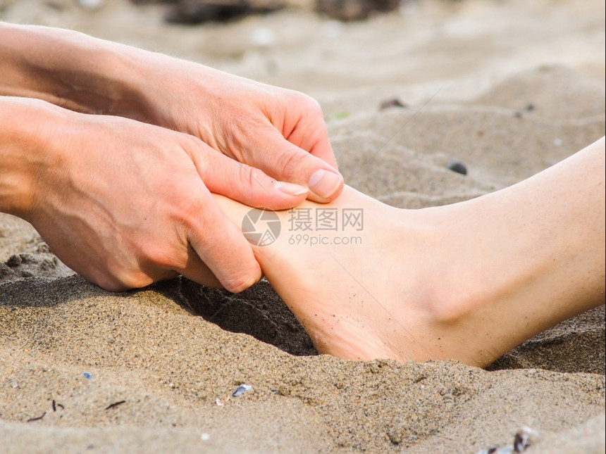 在沙滩上进行脚按摩男女天主教徒女天主教徒户外按摩师宠爱图片