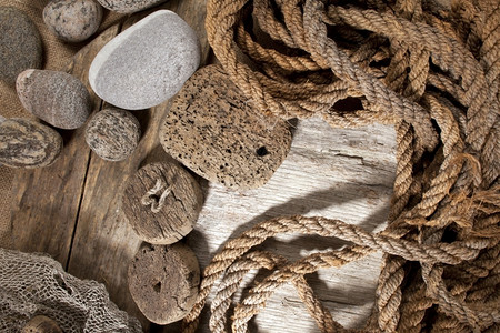 港口海滩木制背景的雕刻绳子和石头支撑图片