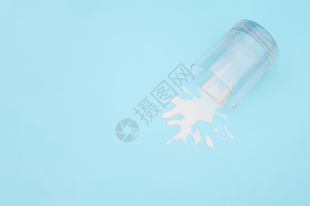 翻车杯子放弃肮脏的溢出牛奶蓝色背景上加牛奶的翻转玻璃乳制品废弃概念复制空间顶视图溢出的牛奶背景