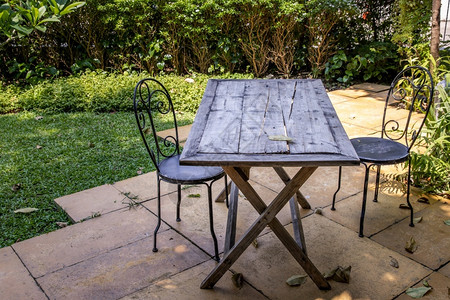 旧木板桌和两张黑钢椅子供户外花园放松黑色的闲暇图片
