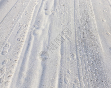 车轮在积雪路上的标记拍摄了车轮的近距痕迹覆盖天气脚印图片