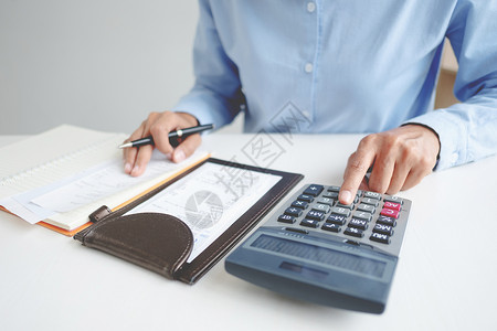 桌子计算器妇女利息收费和税概念的数量贷款背景图片