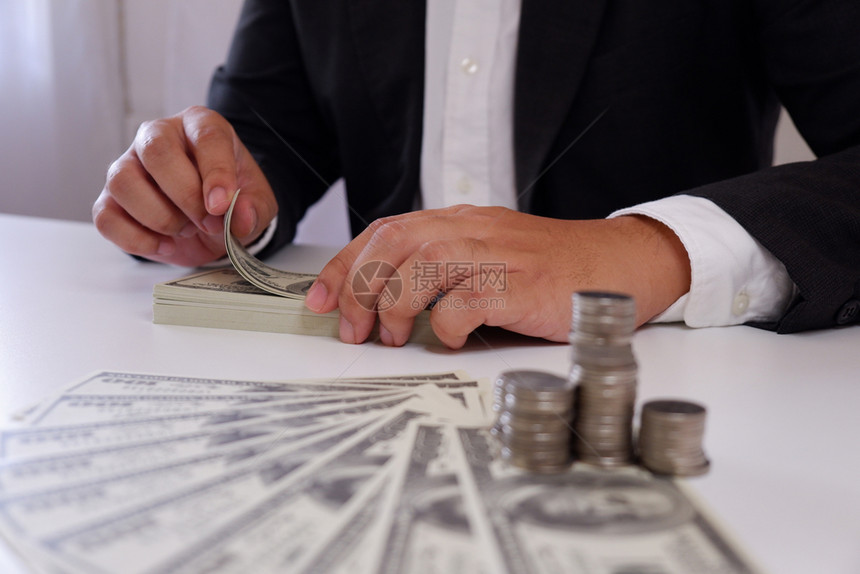 节省人类分析师商在办公桌上用硬币和钱数钞票图片