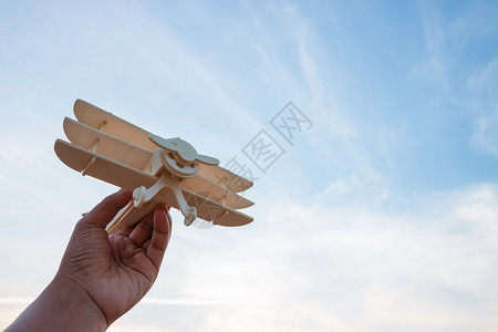 白种人快乐的趣自由概念人类手握木机在日落的天空背景上图片