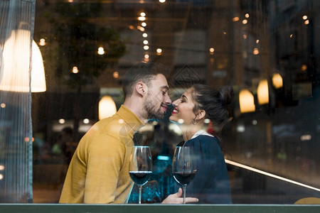 靠近玻璃葡萄酒餐厅的快乐男人白种女士丈夫图片