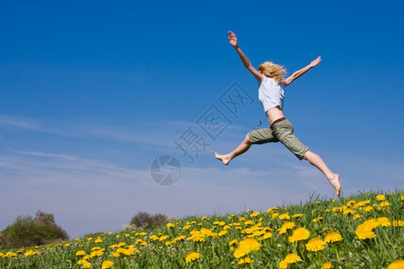 成功夏天年轻女子在花朵茂盛的草原上玩得开心愉快图片