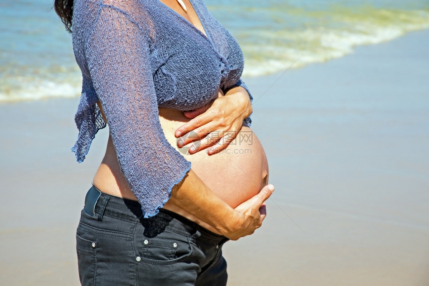 快乐的孕妇在海滩上大西洋的海滨太阳淑女乐趣图片