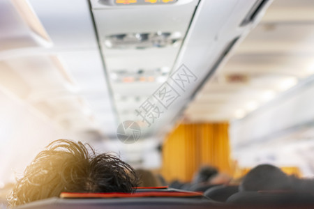 飞机头发素材排航班一架飞机的内走廊飞机头顶有黑发厚的乘客口旅行和交通方式的概念旅行和运输方式概念椅子背景