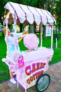 棉布女孩在城市公园卖甜棉花女孩在城市公园卖甜棉花柜台粉色的图片