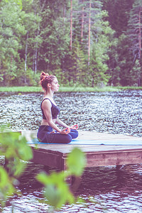 绥靖在美丽湖码头的青年瑜伽女孩默念安宁健康生活方式的概念在美丽湖口训练象征海报背景