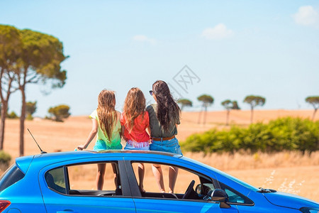 汽车45度暑假汽车度时妈和两个小女孩的背影夏假期中母亲和两个小女孩的背影们司机年轻的背景