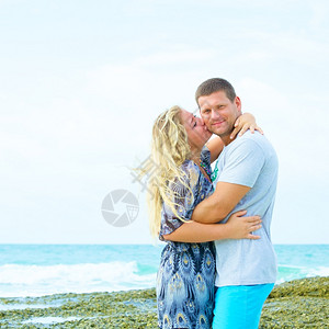 漂亮的夏日在海滩亲吻一对穿便衣的情侣肖像蓝色男人图片