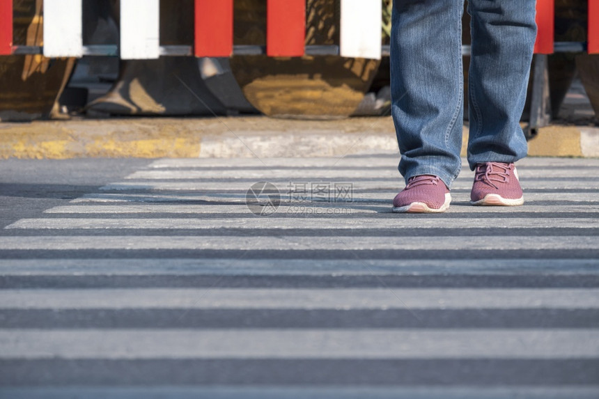 红色的在公共场所斑马交叉口的街对面行走的人腿前视角男复制图片