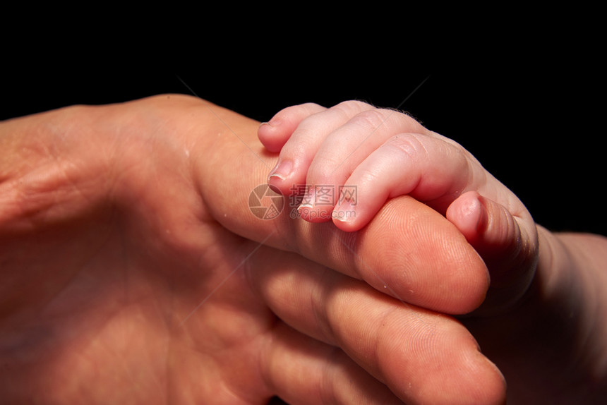 接触新生人们成持有的婴儿手图片