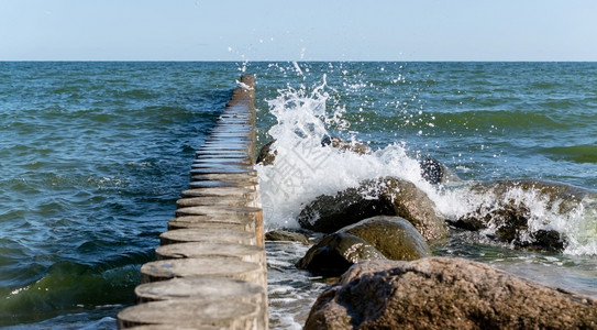 海滨景观重的浪和风暴冲击防波堤海浪溅起罗的浪溅起波罗的海浪和风暴图片