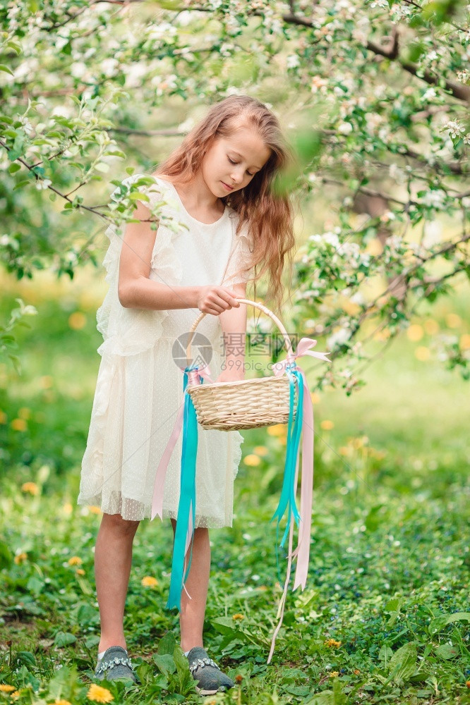 可爱的小女孩长发在盛开的苹果树花园寻找复活节鸡蛋可爱的小女孩在美丽的春天秋在盛开的苹果花园季节眼睛开图片