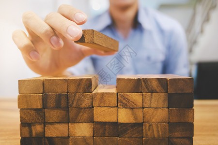运气风险和战略财富计划人与木制板搭手思考价值投资砖银行业图片