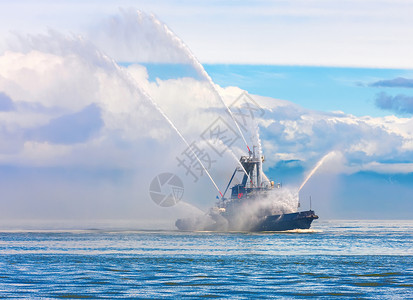 血管喷泉消防船浮动拖正在喷射水柱浮动拖船正在喷射水柱背景图片