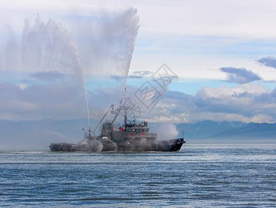 漂浮的海运输动拖船正在喷射水柱浮动拖船正在喷射水柱图片