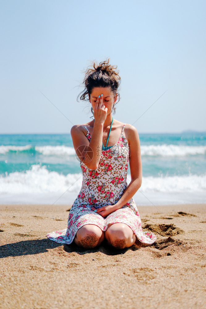 坐在沙滩上穿暑期服装的年轻女子每天练习瑜伽呼吸锻炼女冷静的健康图片