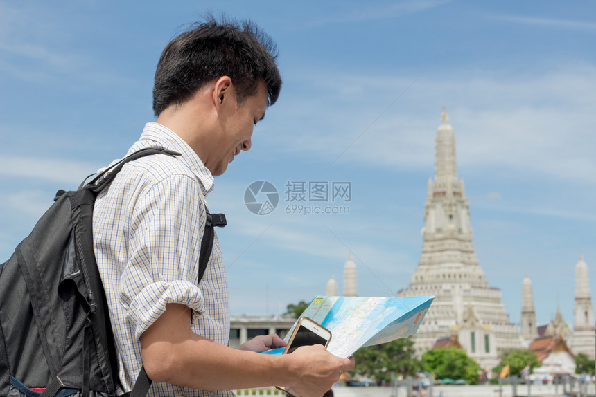 一种在泰国WatArun身穿格衬衫手持智能机及的男子人图片