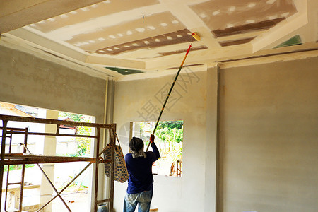 优质的油漆工在画新家的天花板蓝色底部背景图片