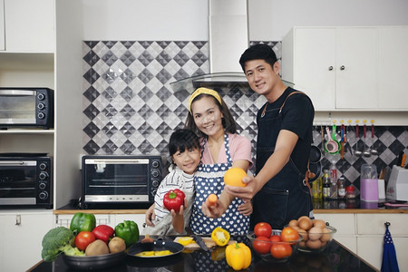 快乐的家庭有爸妈和她们的女儿在厨房一起烹饪笑声父母帮助男人图片