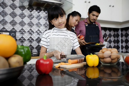 快乐的家庭有爸妈和她们的女儿在厨房一起烹饪笑声美丽的男儿子图片